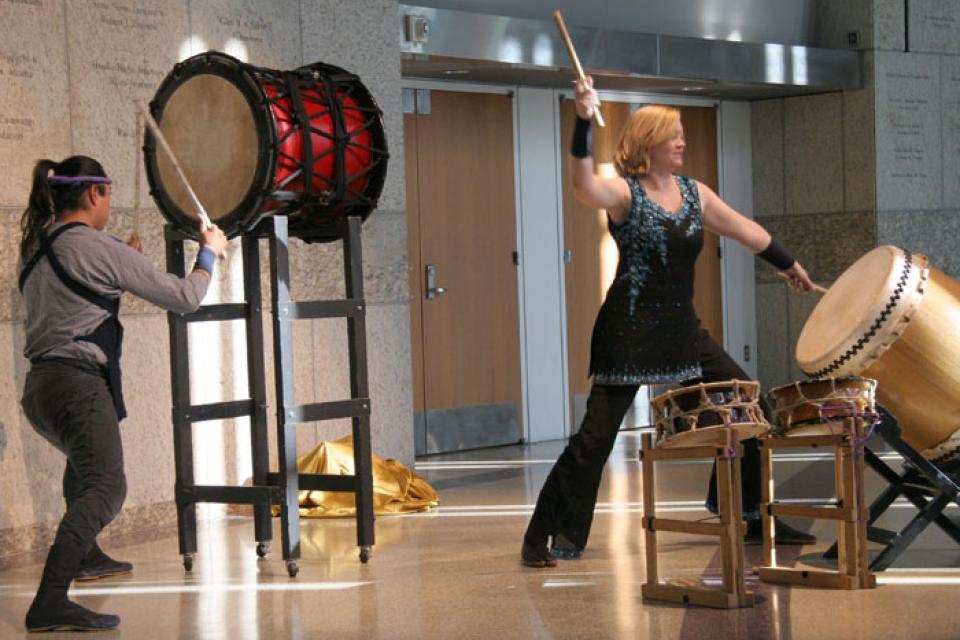 David and Heidi in mid drum-strike at a performance event